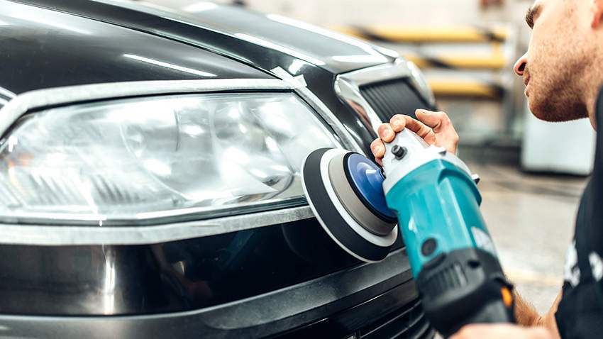 Man polishing a foggy car headlamp