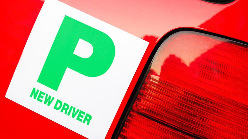 Close-up of a New Driver P plate on the rear of a red car