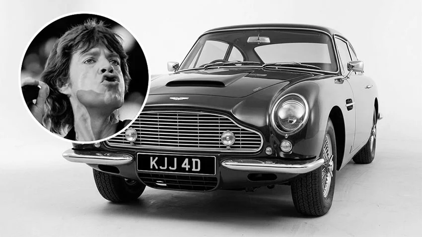 Black and white image of Mick Jagger with his classic Aston Martin, featuring the UK number plate KJJ 4D.