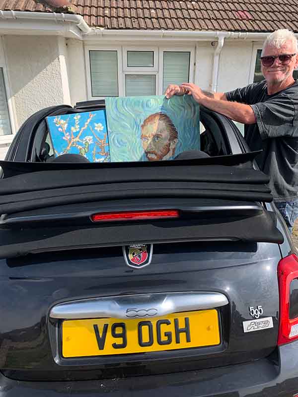 David Henty with his art, and car displaying V9 OGH