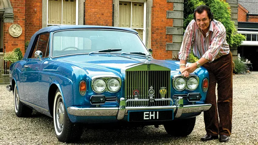 Engelbert Humperdinck next to a blue Rolls-Royce Corniche with EH 1 number plate