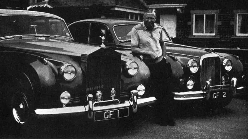 Black and white image of George Formby with a car displaying GF 1 number plate