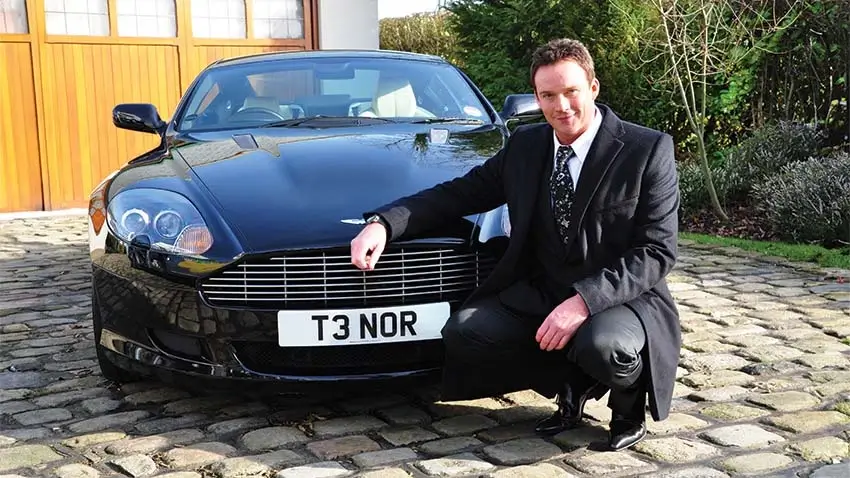 Russell Watson next to an Aston Martin with T3 NOR number plate